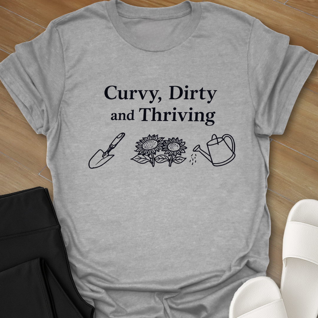 Curvy Dirty and Thriving gardening shirt with serif text and line art of shovel, sunflowers, and watering can on black background