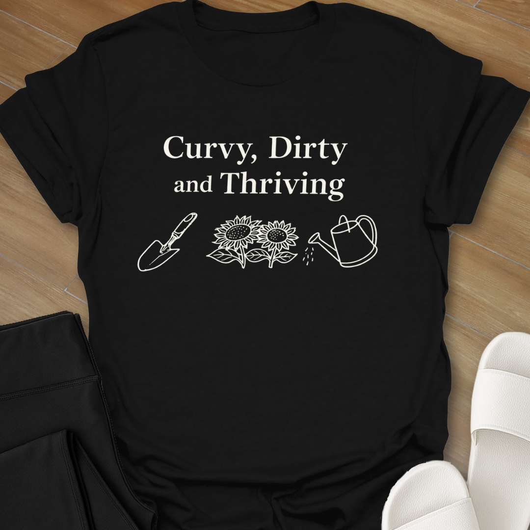 Curvy Dirty and Thriving gardening shirt with serif text and line art of shovel, sunflowers, and watering can on black background