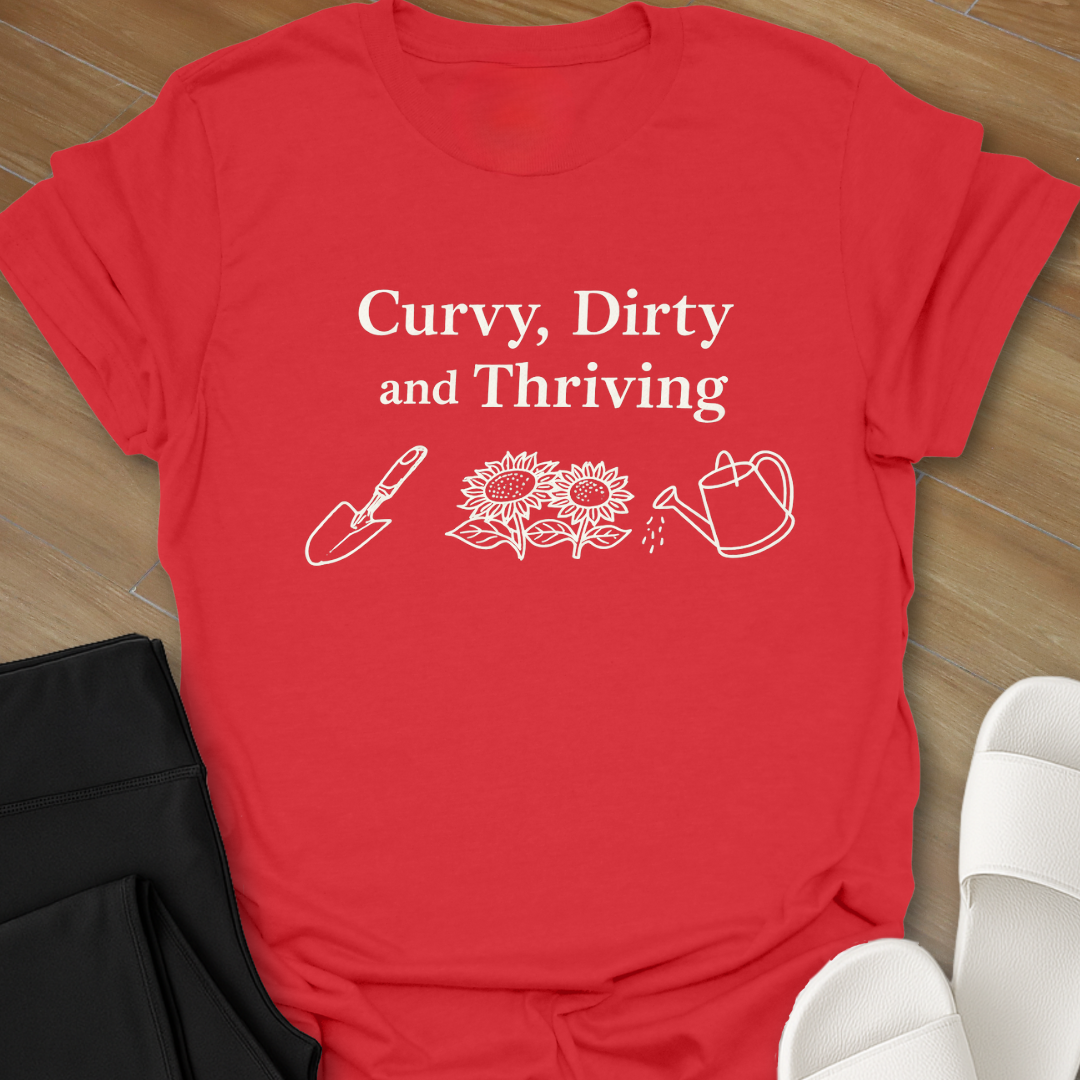 Curvy Dirty and Thriving gardening shirt with serif text and line art of shovel, sunflowers, and watering can on black background
