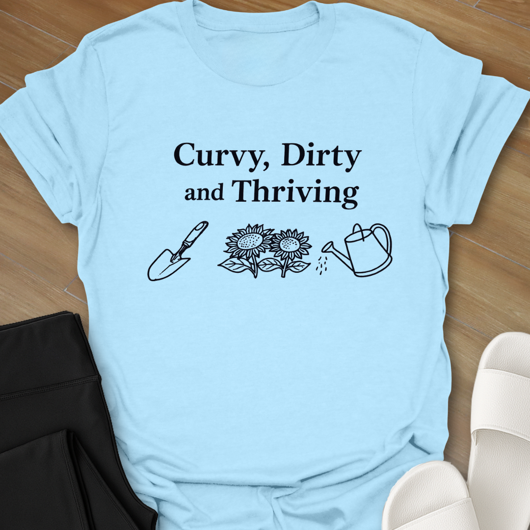 Curvy Dirty and Thriving gardening shirt with serif text and line art of shovel, sunflowers, and watering can on black background